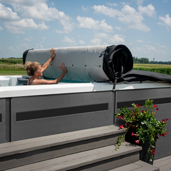 Kobieta odsuwająca pokrywę swojego swim spa.