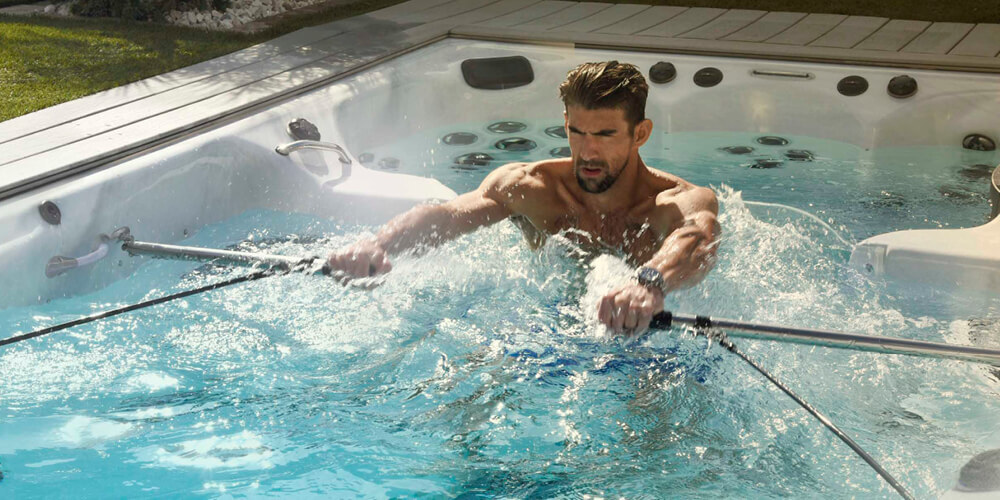Phelps wiosłuje z zestawem do ćwiczeń w basenie spa.